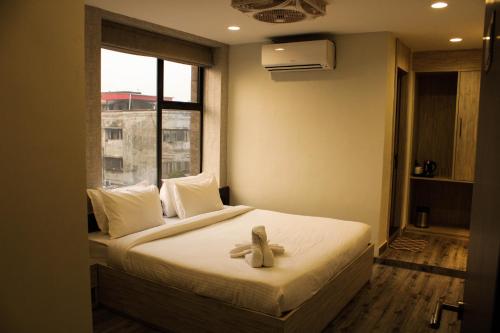 a room with a bed with a teddy bear on it at HOTEL 16 AVENUE in Kolkata