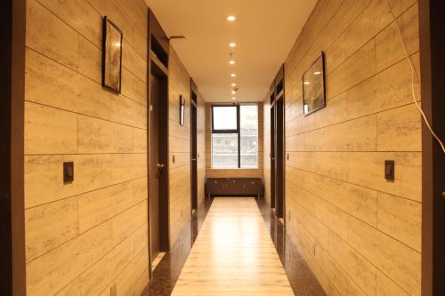 a hallway with wood paneling and a window at HOTEL 16 AVENUE in Kolkata