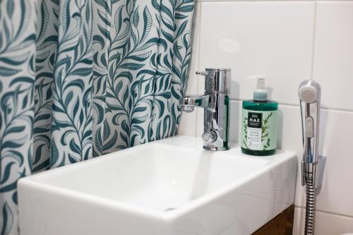 a sink in a bathroom with a shower curtain at Grannys cottage in Laihia