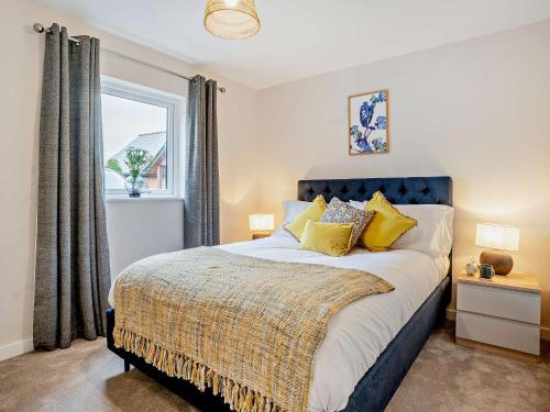 een slaapkamer met een bed met gele kussens en een raam bij 3 bed property in Gower South Wales 91727 