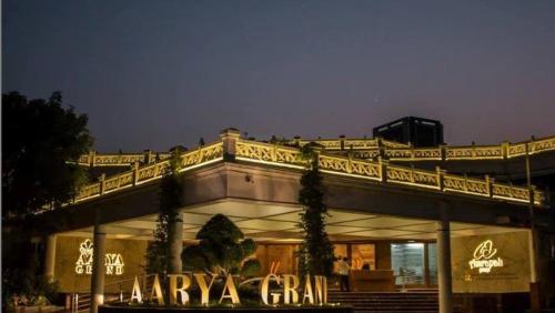 a building with a lit up sign in front of it at Hotel Aarya Grand in Sarkhej