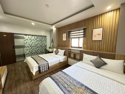 a hotel room with two beds and a window at Cat Ba Seoul 2 Hotel & Apartment in Cat Ba