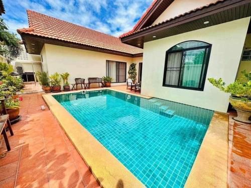 a swimming pool in front of a house at Bali Style Luxury View Talay POOL VILLA close to Beach & Walking Street! in Jomtien Beach
