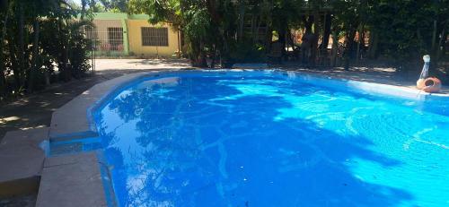 a swimming pool with blue water in a yard at Casa en Villa Marchena azua in Azua de Compostela