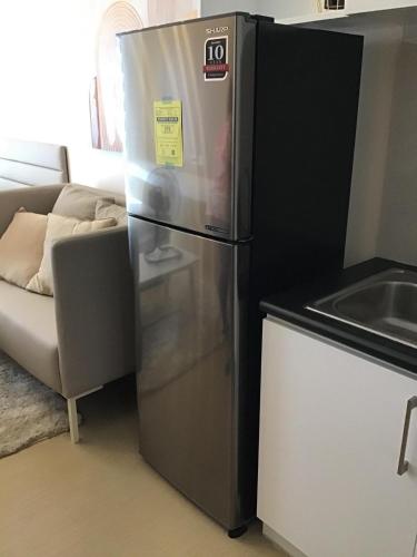 a stainless steel refrigerator in a kitchen with a couch at Studio Type Bedroom in Iloilo City