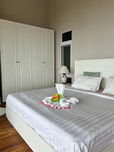 a white bed with a stuffed animal on it at Grand view @lamaibeach in Koh Samui 