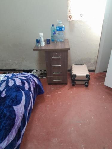 Cette chambre comprend un lit et un bureau avec une valise. dans l'établissement Edge guest room., à Macleantown
