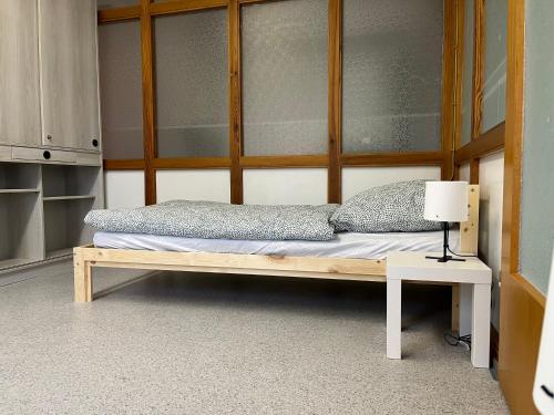Bett in einem Zimmer mit einer Lampe auf einem Tisch in der Unterkunft Geräumiges Monteurzimmer für 2 Personen in Lauda-Königshofen