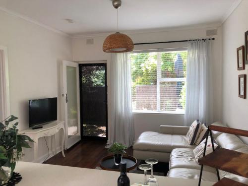 a living room with a couch and a tv at MRS BROWN’s COMFY CITY PAD in Norwood