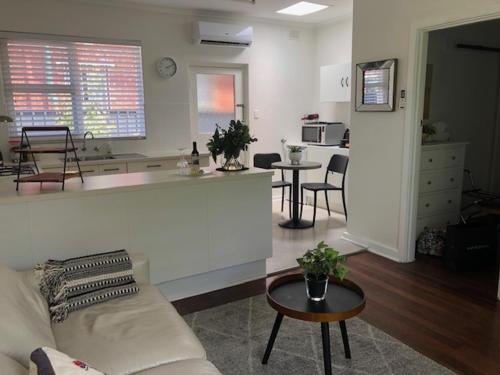 a living room with a couch and a kitchen at MRS BROWN’s COMFY CITY PAD in Norwood