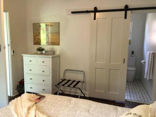 a bedroom with a bed and a dresser and a door at MRS BROWN’s COMFY CITY PAD in Norwood