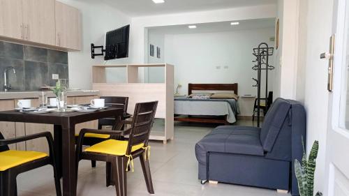 a kitchen and living room with a table and a couch at Céntrico Monoambiente con Parrillero Privado in Tarija