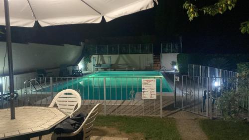 - une piscine avec 2 chaises et un parasol la nuit dans l'établissement PePe house, à Capannori