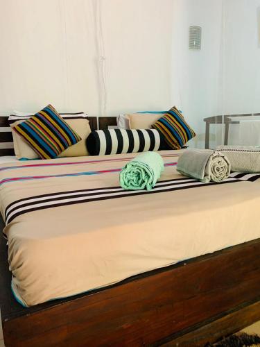 a bed with several pillows on top of it at Little Cottage in Ella