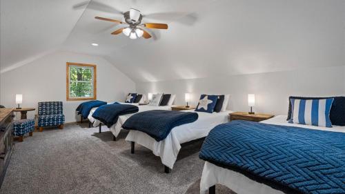 1 Schlafzimmer mit 4 Betten und einem Deckenventilator in der Unterkunft New! The Stone House On Pelican Lake in Breezy Point