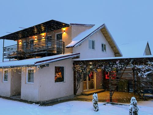 una casa está cubierta de nieve con luces en Casuta din Deal en Ucea de Sus