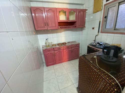 盧克索的住宿－Mayane home，一间带红色橱柜和炉灶的厨房