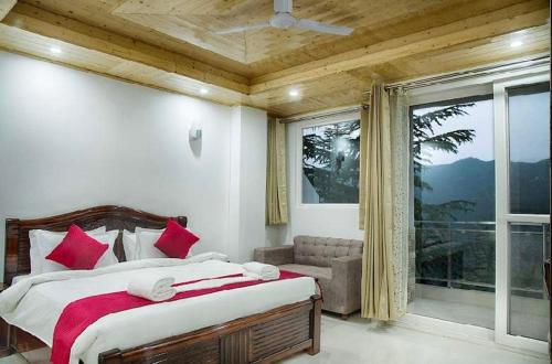 Schlafzimmer mit einem Bett mit roten Kissen und einem Fenster in der Unterkunft Green Valley Chail in Chail