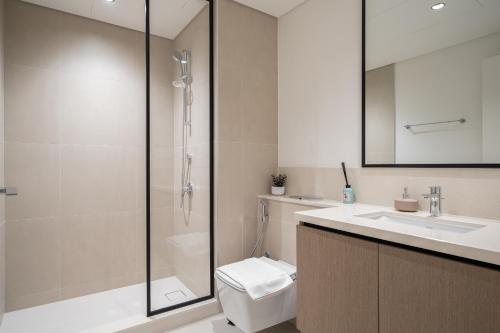 a bathroom with a shower and a toilet and a sink at Sky-High Central Dubai Gem: Burj Khalifa & Fountain View in Dubai