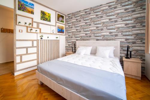 a bedroom with a white bed and a stone wall at ""Comfort 14'' in Miskolc