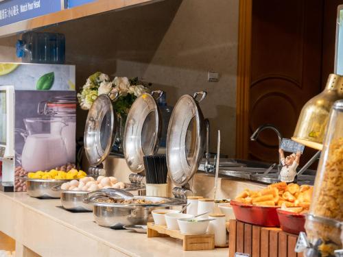 un mostrador con platos y otros alimentos. en Vienna International Hotel Wuhan Jiefang Avenue, en Wuhan