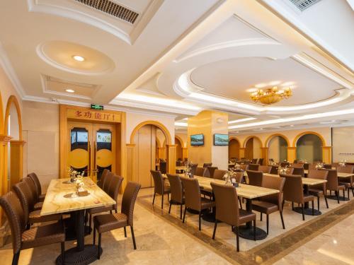 Un restaurante con mesas y sillas y un techo. en Vienna International Hotel Wuhan Jiefang Avenue, en Wuhan