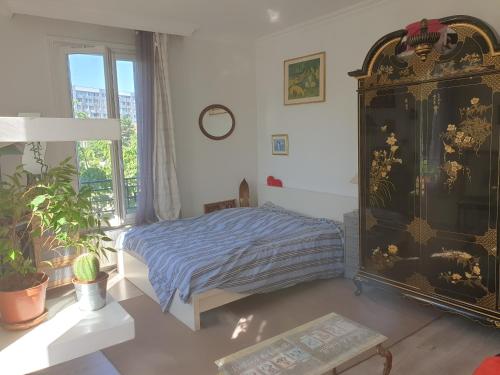 a bedroom with a bed and a large window at Villa proche JO 2024 in La Courneuve