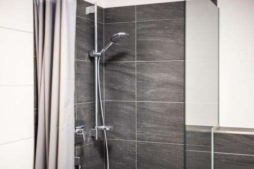 a shower in a bathroom with a glass door at myQuartier Central City Suites in Innsbruck
