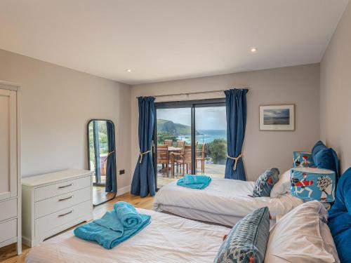 a bedroom with two beds and a view of the ocean at Blue Seas in Mawgan Porth