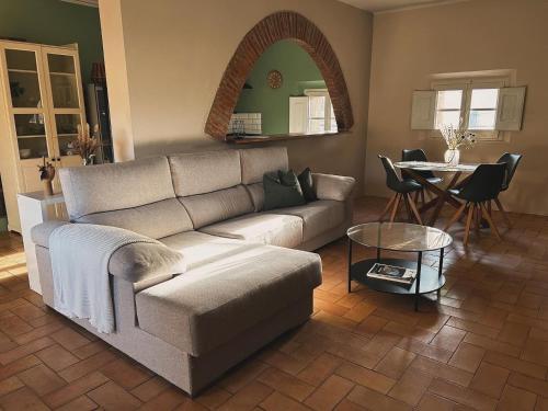 a living room with a couch and a table at Cal Robusto, Apartament in Masía with horses in Siurana