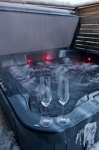two wine glasses sitting in a hot tub with snow at Polaris Igloo by Aavalevi in Levi