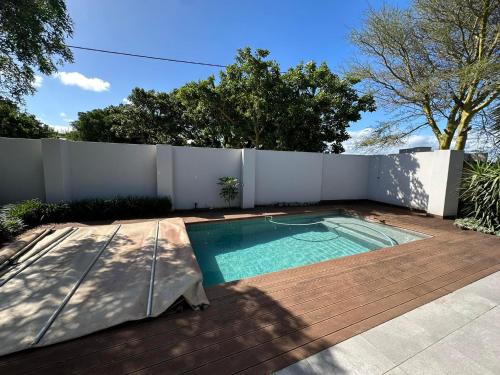 a swimming pool in a backyard with a fence at Luxury holiday home 3 bedroom, 3 bathroom house in Nahoon in East London