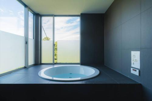 a large tub in a room with a large window at unito Villa FUTTSU Takeoka in Futtsu