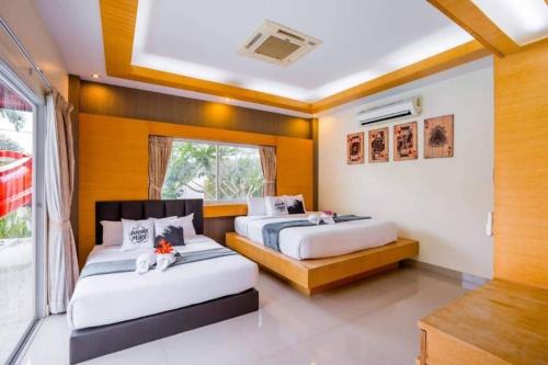 a bedroom with two beds and a window at Unique Pool Villa Resort in Ban Map Fakthong