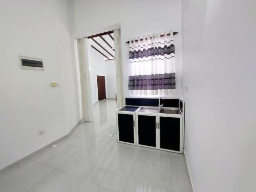 a white room with a sink and a mirror at Comfortable Stay in Colombo in Rajagiriya