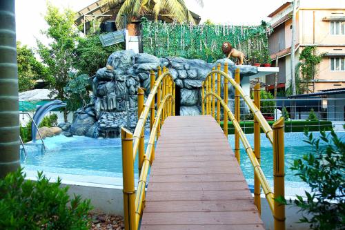un parque acuático con una pasarela de madera que conduce a una piscina en Lake Palace Family Resort Kumarakom, en Kumarakom