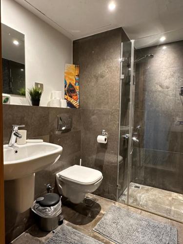 a bathroom with a shower and a toilet and a sink at Bright & Lovely 2 Beds Apartment in Scarab Club, El Gouna in Hurghada