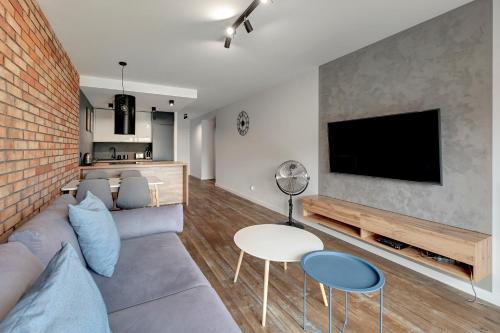 een woonkamer met een bank en een tv bij Rezydencja Wintera Apartments by Grand Apartments in Gdańsk