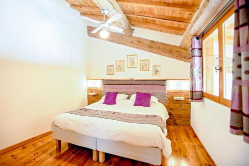 - une chambre avec un grand lit et des oreillers violets dans l'établissement La Maison Des Vignes - Gite Lavande - Luxury Gite with Air Conditioning, à Tourouzelle