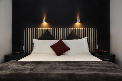 a bedroom with a large white bed with two pillows at Adara Hotel Richmond in Melbourne