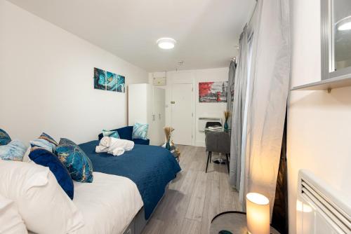 een kleine kamer met een bed en een bureau bij Cozy Ground-Floor Studio, Excellent City Access in Londen