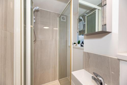 a bathroom with a shower and a sink at Cozy Ground-Floor Studio, Excellent City Access in London