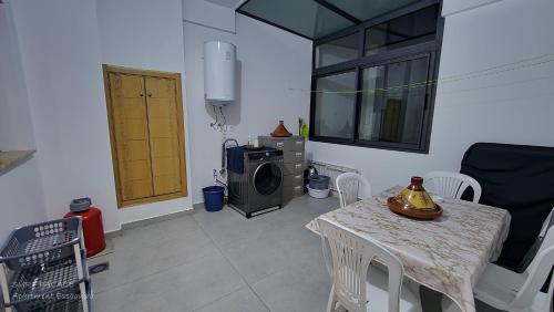 a living room with a table and a microwave at SURF PALACE BEACHFRONT APARTMENT Essaouira in Essaouira