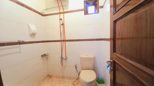 a bathroom with a toilet and a shower at Homestay Jogja Gejayan Dekat Pakuwon Mall by Simply Homy in Yogyakarta