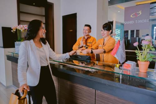 a woman standing at a counter in a store at Sahid T-More Hotel in Kupang