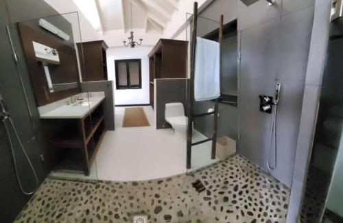 a bathroom with a shower and a toilet and a sink at Lux Villa w/ Stunning Panoramic Ocean Views in Bequia