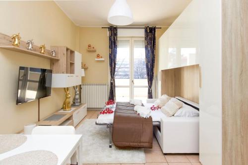 ein Wohnzimmer mit einem Sofa und einem TV in der Unterkunft STAR Suite, Malpensa - Rho Fiera Milano 15 min in Legnano