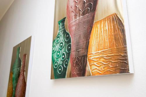 Zwei Bilder von Vasen hängen an einer Wand in der Unterkunft STAR Suite, Malpensa - Rho Fiera Milano 15 min in Legnano