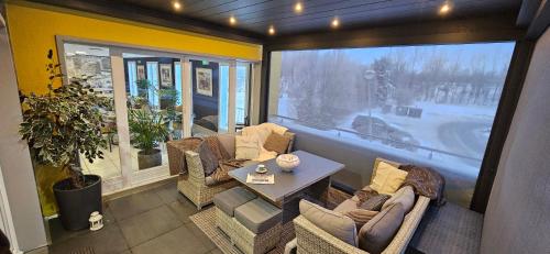 a room with chairs and a table and a large window at Hotel-Restaurant Stand'Inn in Foetz