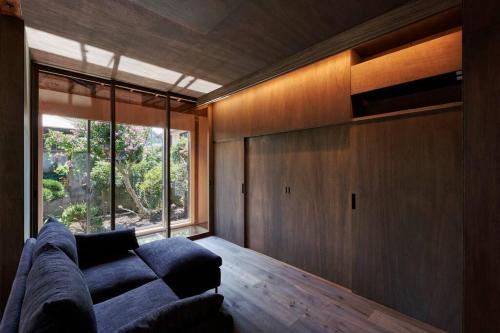 a living room with a couch and a large window at unito 逗子別邸 in Zushi